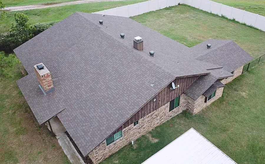A new brown shingle roof on a brick ranch home, photographed by drone