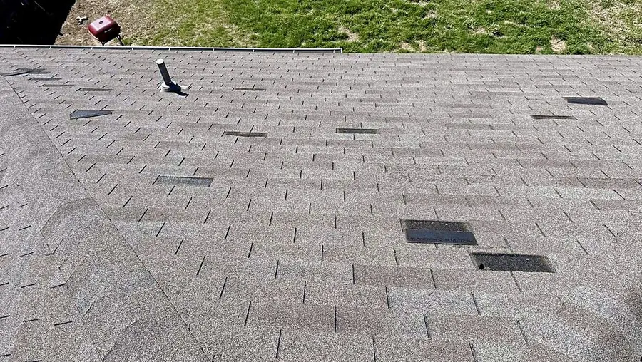 Missing shingle tabs on an asphalt shingle roof slope