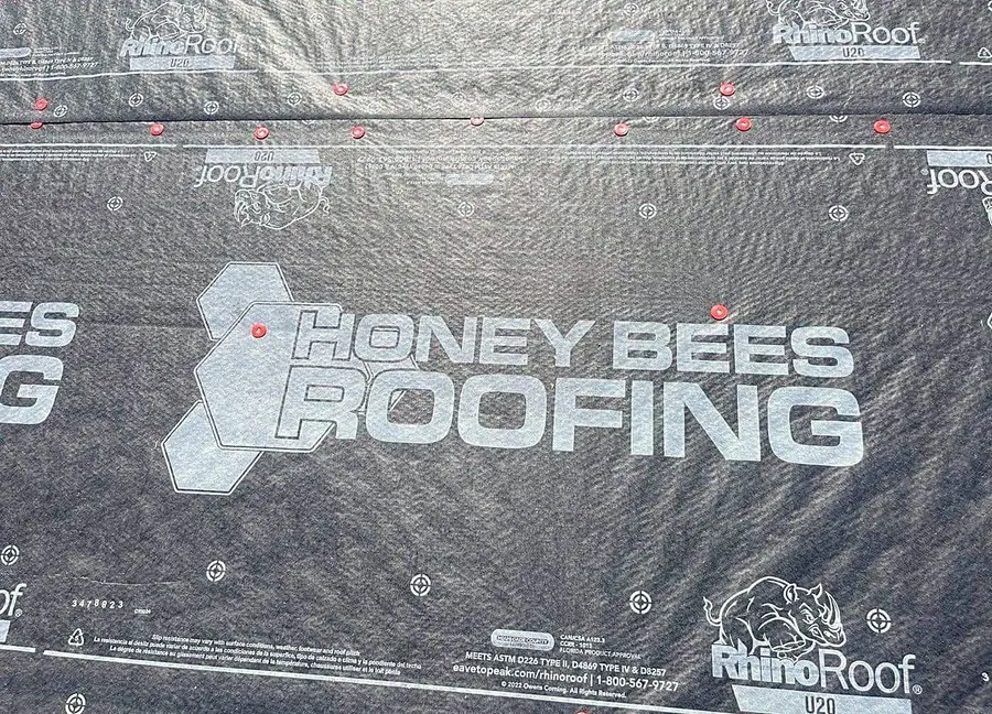 Honey Bees Roofing branded underlayment laid across a dried-in roof